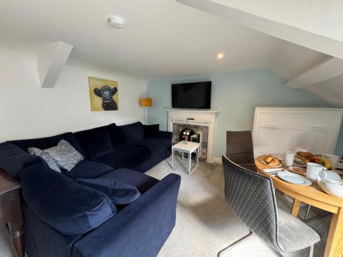 a living room with a blue couch and a fireplace at Abbey View Apartment in the heart of Youghal in Youghal
