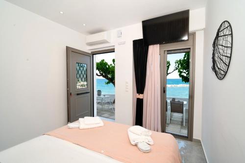 ein Schlafzimmer mit Bett und Meerblick in der Unterkunft Chariklia Studios in Asmínion