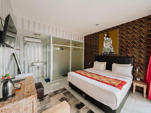 a bedroom with a king sized bed and a desk at Bhuana Agung Villa and Restaurant in Jatiluwih
