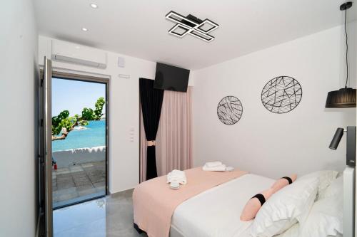 ein Schlafzimmer mit Bett und Meerblick in der Unterkunft Chariklia Studios in Asmínion