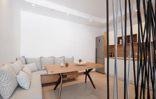 a living room with a couch and a wooden table at Amor Hideaway Villas in Fira