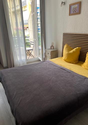 une chambre avec un grand lit avec une grande fenêtre dans l'établissement chez Eva, à Nice