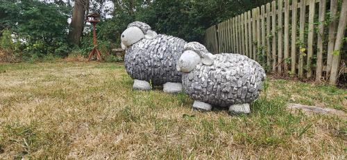 two stuffed animals are standing in the grass at Lilys Cottage Mendlesham Green Stowmarket Suffolk in Stowmarket