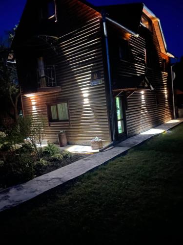 a house with lights on the side of it at night at Pidkova in Verkhovyna