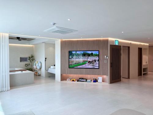 a room with a flat screen tv on a wall at 광안사계스테이 GwanganSagyeStay in Busan