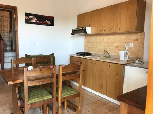 a kitchen with a table and chairs and a sink at Traditional Bungalows in Kalyves Poligirou