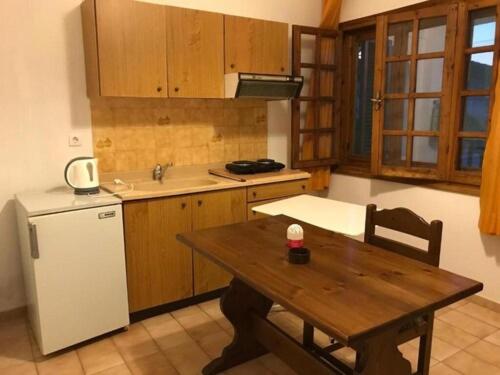 a kitchen with a wooden table and a white refrigerator at Traditional Bungalows in Kalyves Poligirou