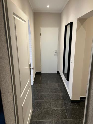 a hallway with a white door and a tile floor at Ruhrperle Apartment 3 Essen in Essen