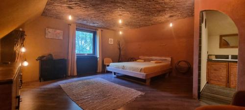 a bedroom with a bed and a large window at Étang des Tamaris in Namur