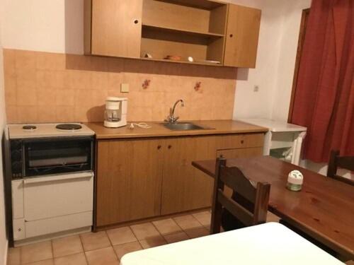 a kitchen with a stove and a sink and a table at Traditional Bungalows in Kalyves Poligirou