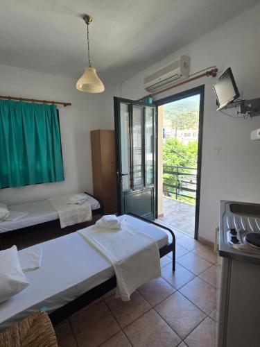 a room with two beds and a door to a patio at Icthyoessa in Agios Kirykos