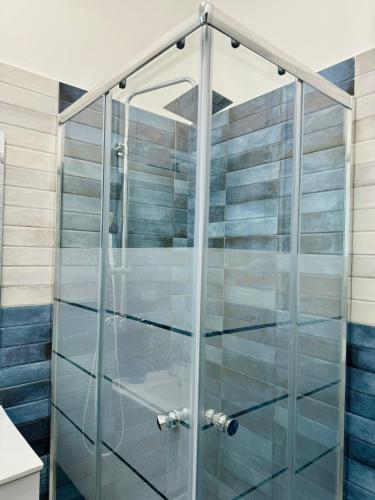 a shower with glass doors in a bathroom at Simone's House in Tuglie