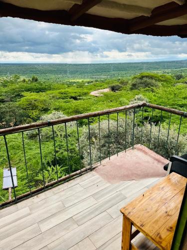 a balcony with a wooden table and a view at Little tree house in Kiserian