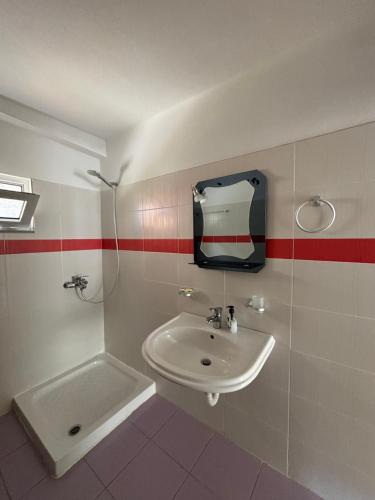 a bathroom with a sink and a mirror on the wall at Blissful Apartments in Sarandë