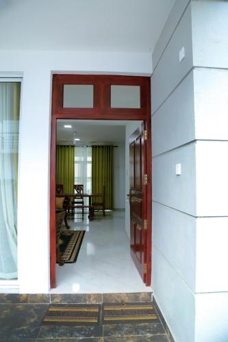 an open door into a room with a table at Rose Villa-AC 3 Bed rooms,15 mins to airport with gated community & swimming pool in Kotugoda