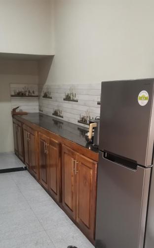 a kitchen with a stainless steel refrigerator and wooden cabinets at Yarl Nest in Jaffna