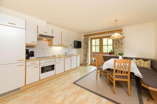 a kitchen and dining room with a table and chairs at Pension Appartements Alpenblick in Maria Alm am Steinernen Meer