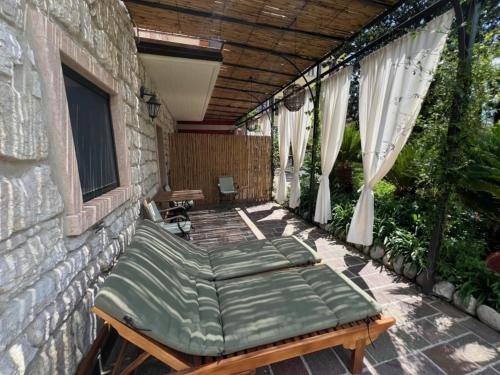 a porch with a bed on a patio at Da Gianni e Villa Annamaria in Arco