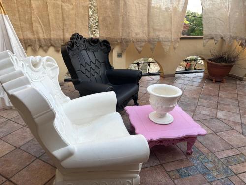 Habitación con 2 sillas blancas y mesa. en Un piccolo castello medioevale vicino 5 Terre, en Giucano