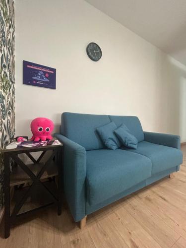 a blue couch in a living room with a table at Nicolosi Apartment in Latina