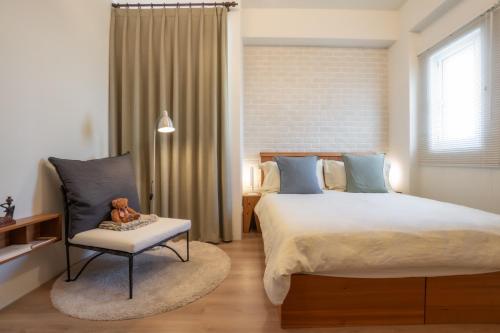 a bedroom with a large bed and a teddy bear on a chair at Shu Sia in Hengchun