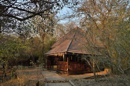a log cabin in the middle of a forest at Grand Kruger Lodge and Spa in Marloth Park