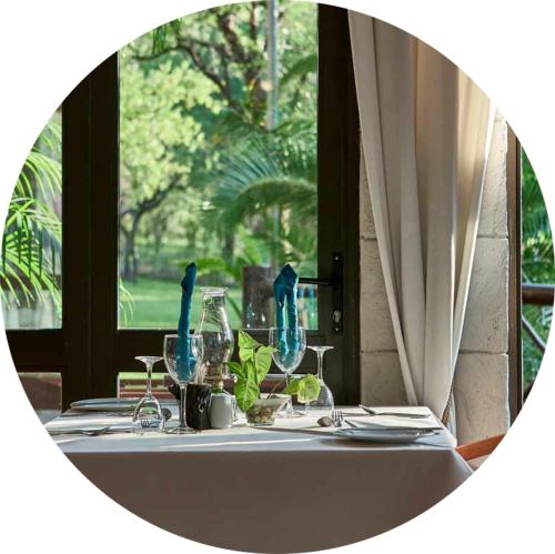 a table with a white table cloth and glasses at Grand Kruger Lodge and Spa in Marloth Park