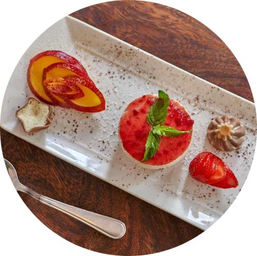 a plate of food with a fruit and a strawberry at Grand Kruger Lodge and Spa in Marloth Park
