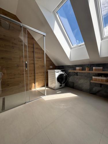 a bathroom with a shower and a ceiling with skylights at Apartmán Šumavské nebe in Prachatice