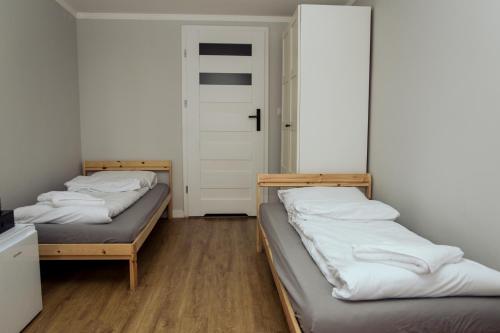 two beds in a room with a door at Ośrodek Wypoczynkowy Świerkocin in Świerkocin