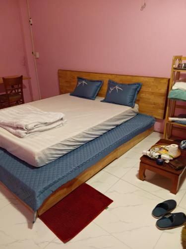 a bed with blue pillows on it in a room at HangNga homestay - hotel in Phủ Từ Sơn