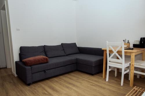 a living room with a gray couch and a table at Ośrodek Wypoczynkowy Świerkocin in Świerkocin