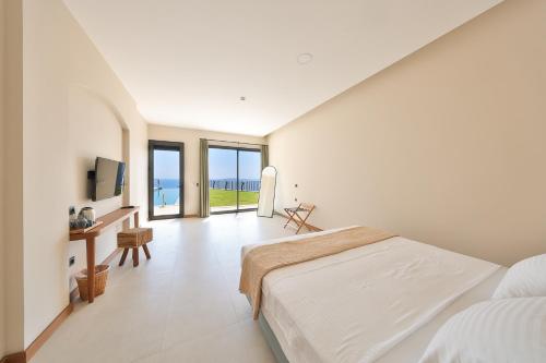 a bedroom with a bed and a desk with a television at Lyxos Hotel in Kas