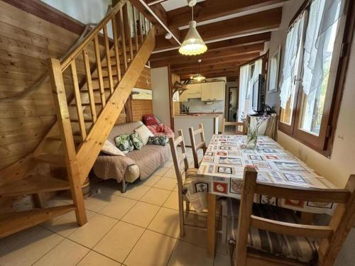 une salle à manger avec une table et un escalier dans l'établissement Belle de jour, à Mézos