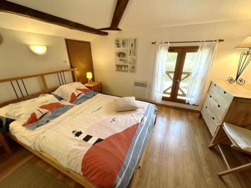 une chambre avec un grand lit et une fenêtre dans l'établissement Belle de jour, à Mézos