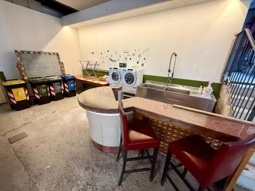 a kitchen with a sink and a counter with chairs at Da Gianni e Villa Annamaria in Arco