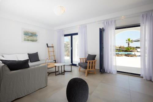 a living room with a couch and a table at Amor Hideaway Villas in Fira