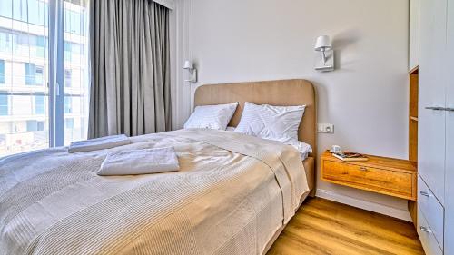 a bedroom with a large bed with a window at Rezydencja Niechorze D210 z 2 sypialniami Eco Boho - 5D Apartments in Niechorze