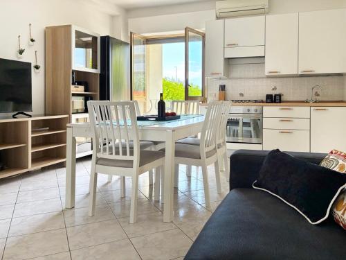 Una cocina con mesa de comedor y sillas. en Holihome Olympia, en Alba Adriatica