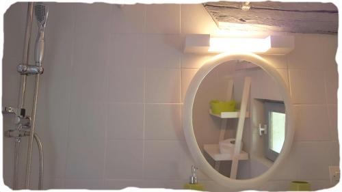 a bathroom with a round mirror and a shower at Bergerie de Bazas Gîte in Lignan-de-Bazas