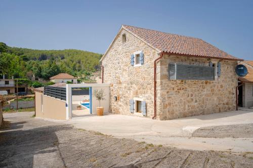 a stone house with a large sliding glass door at Casa Rustivéra - Island Hvar in Vrbanj