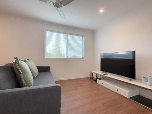 a living room with a couch and a flat screen tv at Family Haven in Sunnybank with 2BR 2Bath 3 Beds in Brisbane