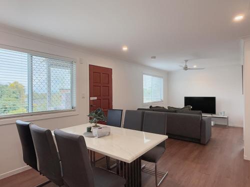 a living room with a table and a couch at Family Haven in Sunnybank with 2BR 2Bath 3 Beds in Brisbane