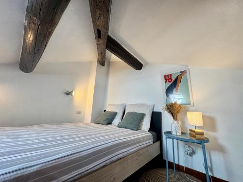 une chambre avec un lit et une table avec une lampe dans l'établissement Studio de charme au coeur de Cannes 2 min plage et 10 Congrés, à Cannes