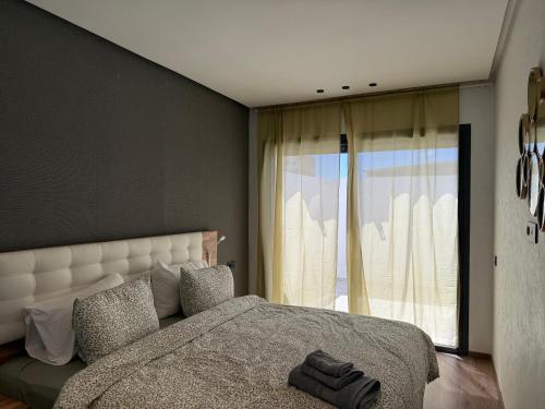 a bedroom with a large bed and a large window at Encore plus beau Studio SeaView 1 in Casablanca