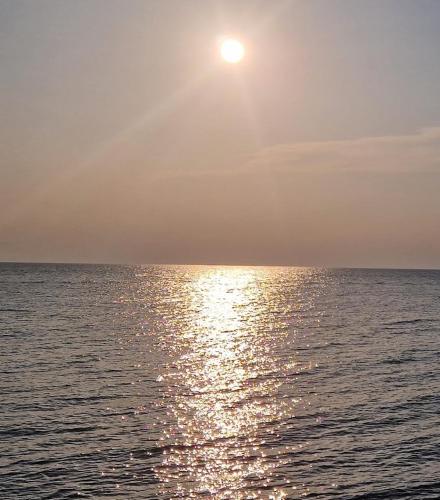a sun setting over the ocean with the water at Apartman Mario in Umag