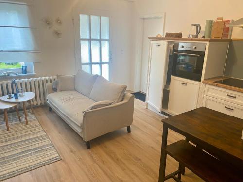 a living room with a couch and a table at Das Garden House - Hohensee Erdgeschoss in Zemitz