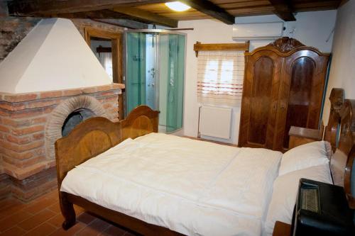1 dormitorio con 1 cama y chimenea de ladrillo en Ekoetno Selo Strug, en Krapje