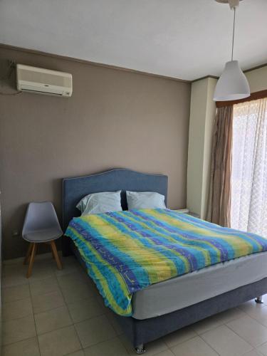 a bedroom with a bed with a colorful blanket at Kons beach front in Kalamata