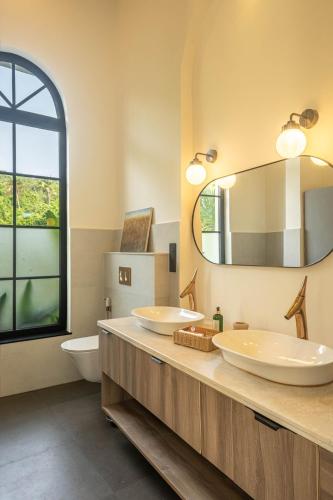 a bathroom with two sinks and a mirror at Morii Homes 4BHK Villa with private pool Parra, Assagao in Parra